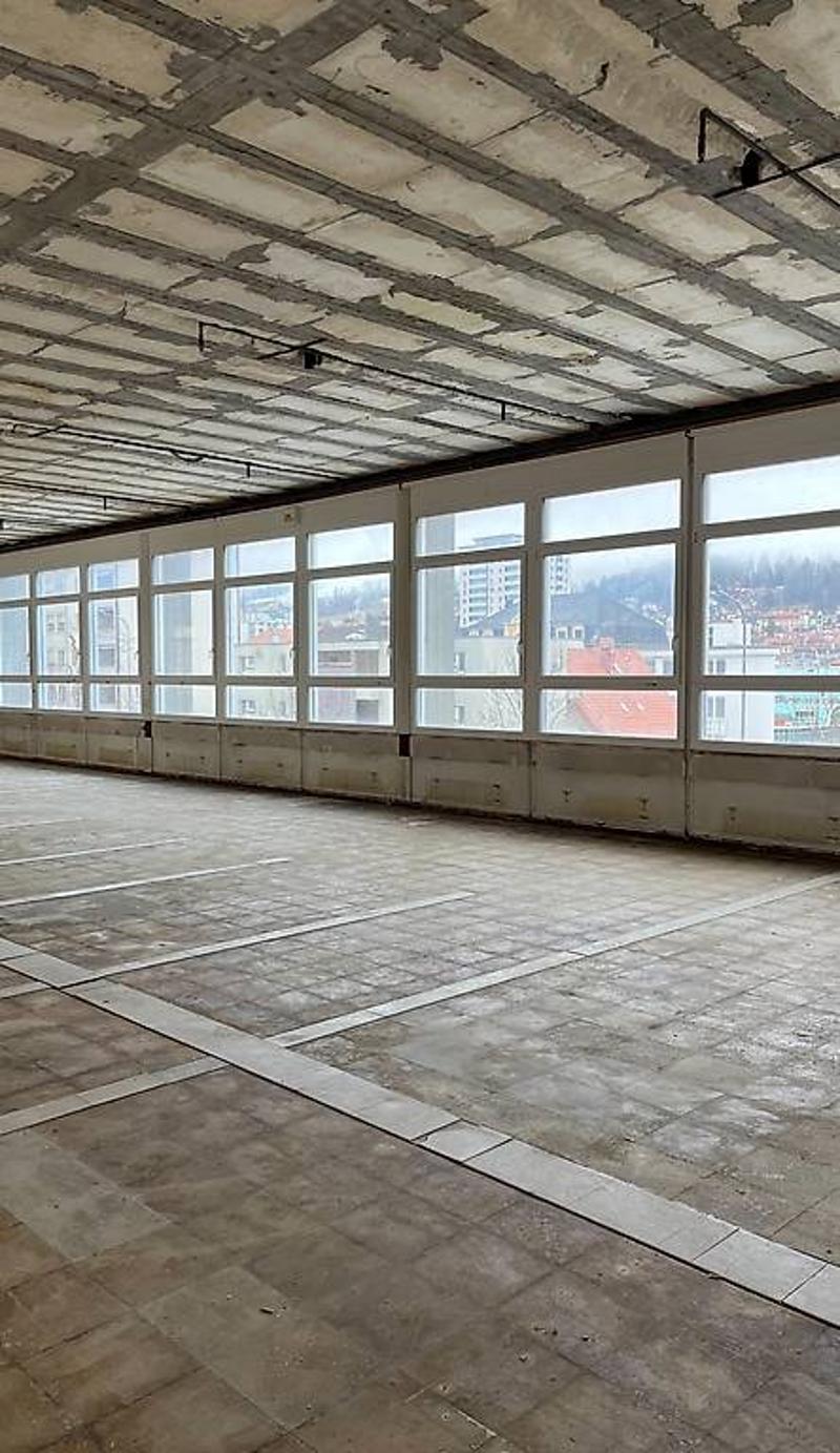 large empty room, concrete floor, white ceiling, large windows, no furniture