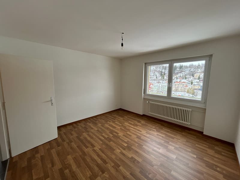 empty room, wooden floor, white walls, large window, radiator, door