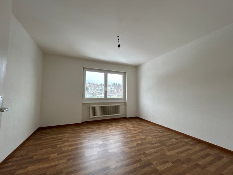 empty room, white walls, wooden floor, large window, white radiator
