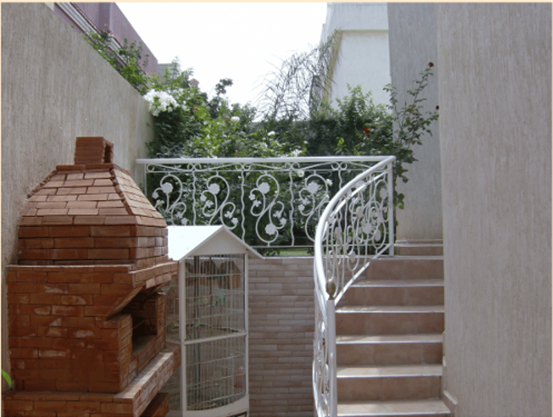brick fireplace, spiral staircase, white metal railing, white cage