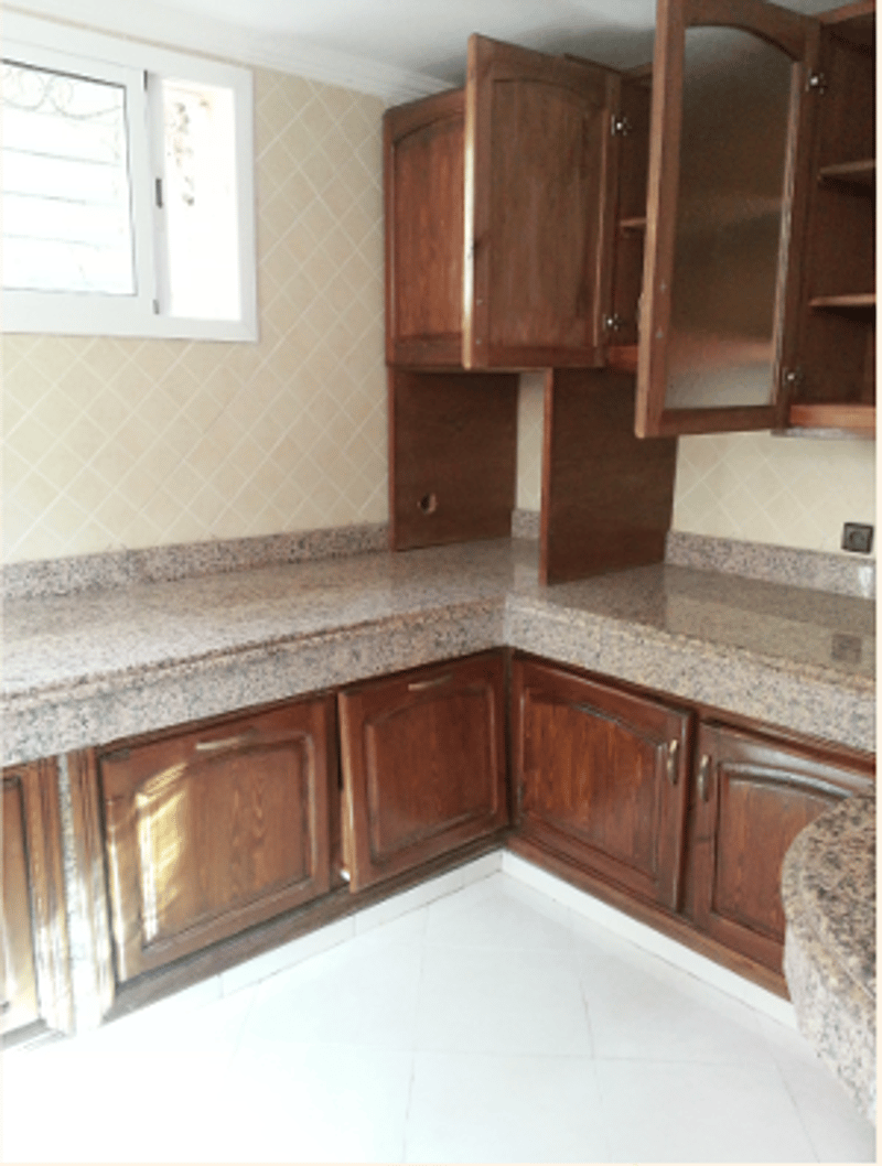empty kitchen with granite countertops, wooden cabinets, white tiles, and two open cupboards