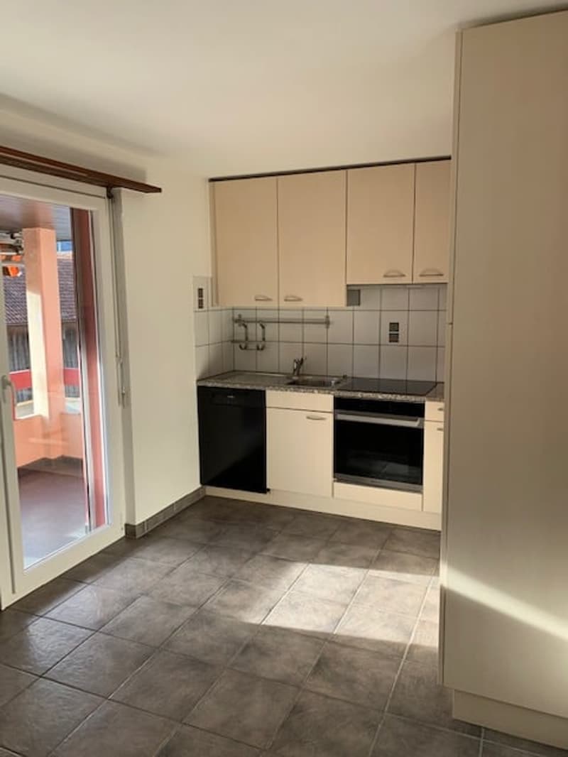 Empty kitchen with appliances, cabinets, tile flooring, balcony