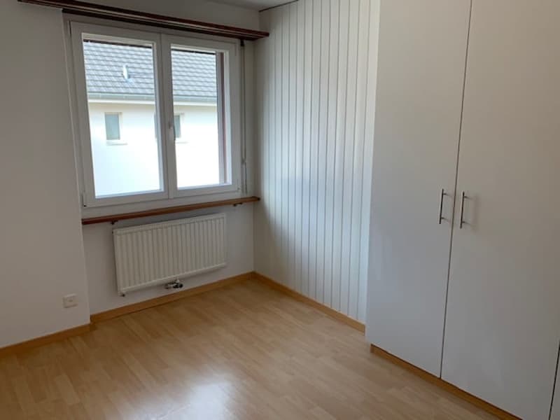 empty room, wooden floor, white walls, large window, white radiator, white wardrobe