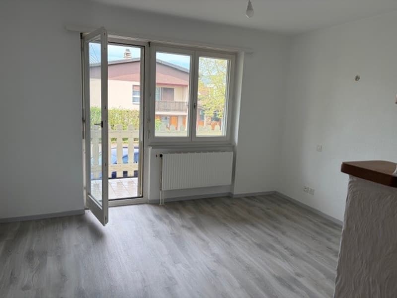 empty room, white walls, wooden floor, sliding glass door, white radiator, open balcony
