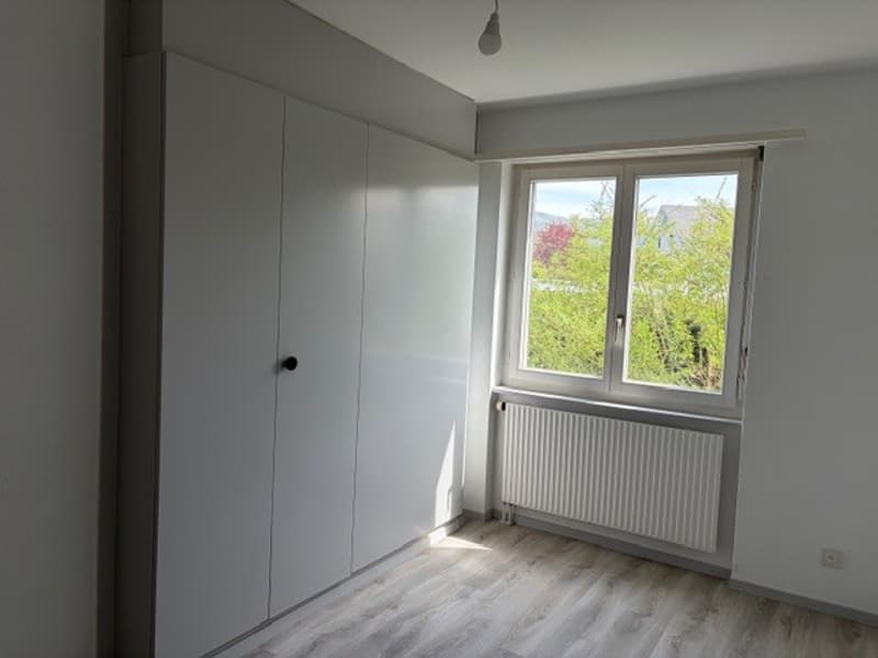 empty room, white walls, wooden floor, white wardrobe, window with white radiator