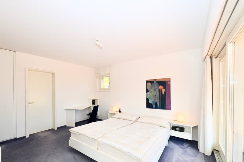 double bed, desk with chair, painting on wall, nightstands, white bedding, lamps