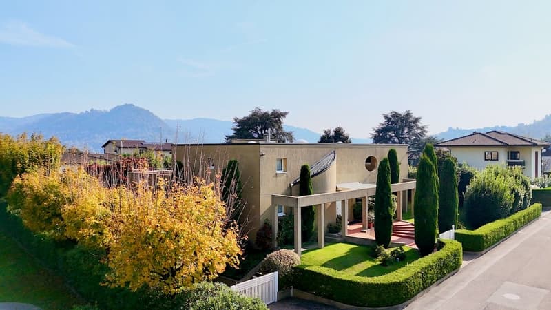 Detached house with raised ground floor, terrace, garden, driveway, mountains in the background
