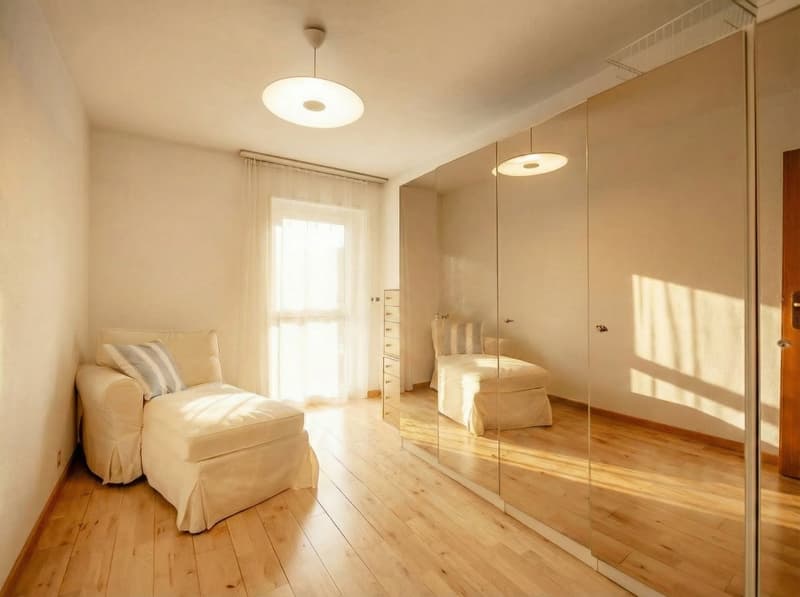modern room with white walls, wooden floor, large mirror, white sofa, white chair, white curtains, ceiling lamp