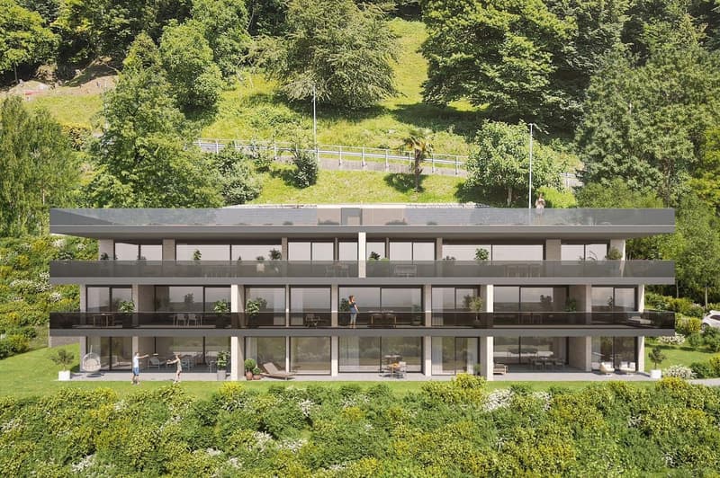 Modern building with glass balconies, raised ground floor, and a view of the mountain.
