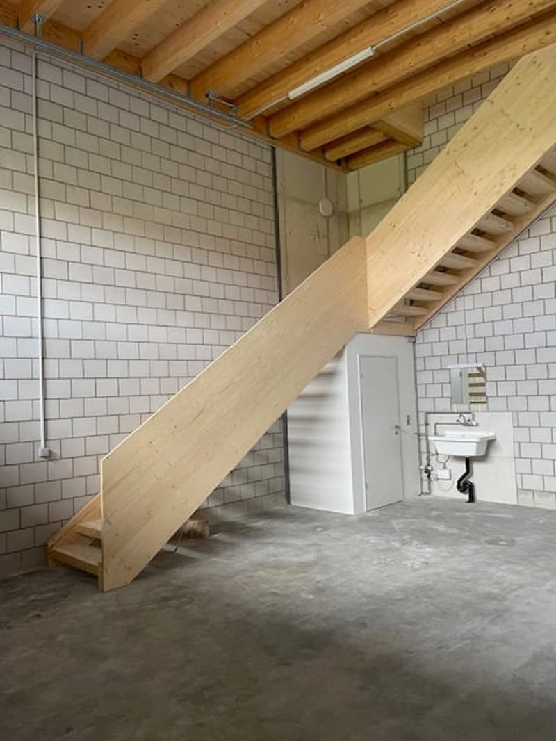 Wooden stairs, white tiled walls, wooden ceiling