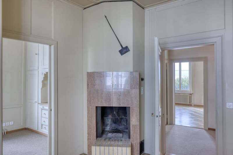 empty room, fireplace, white walls, white doors, white cabinets, shovel on wall