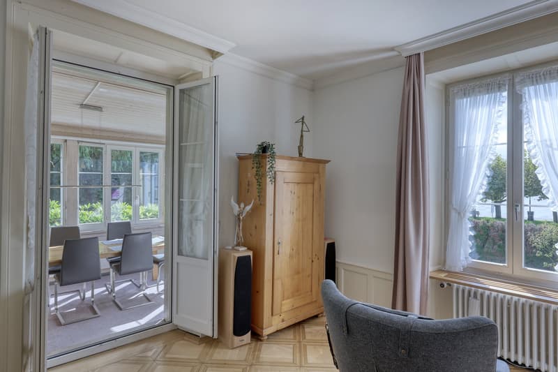wooden floor, wooden cabinet, dining table, chairs, speakers, radiator, windows, curtains
