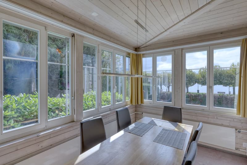 dining room with large windows, wooden table, chairs, yellow curtains, view of the outside