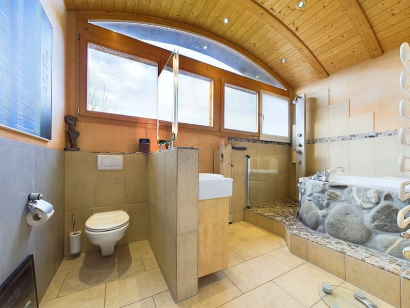 modern bathroom with white toilet, sink, shower, and bathtub