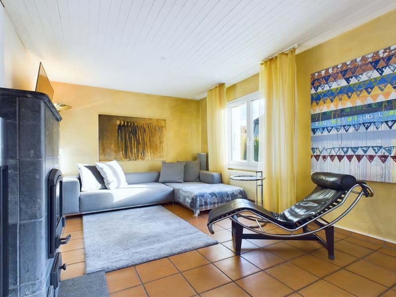 yellow walls, fireplace, grey couch, white throw pillows, side table, lounge chair, area rug