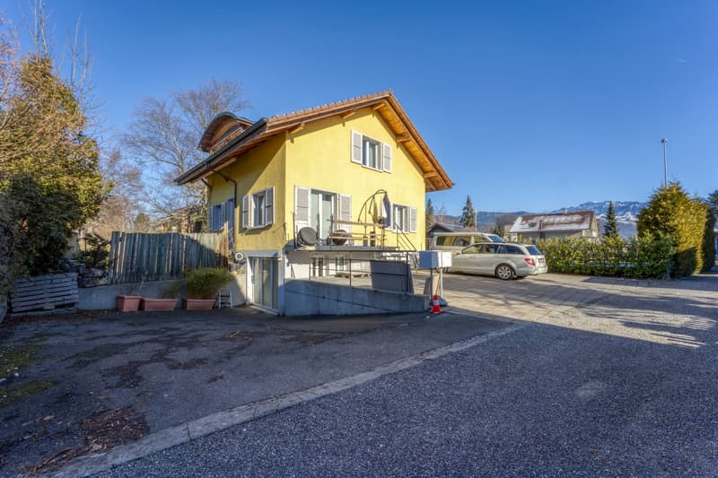 2 story yellow house, white windows, brick roof, garage
