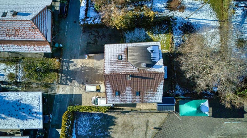 Single-family house, brown roof, 3 cars parked in front, winter scenery