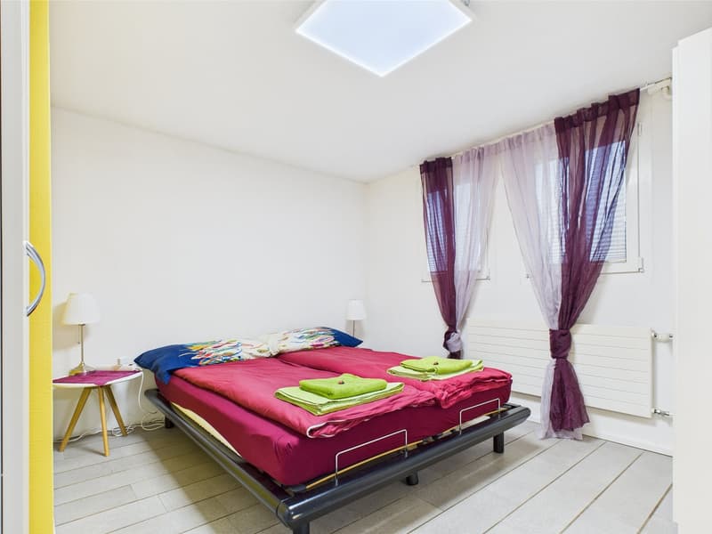 white room, 2 beds, purple curtains, ceiling light, window, lamps, white table, towels