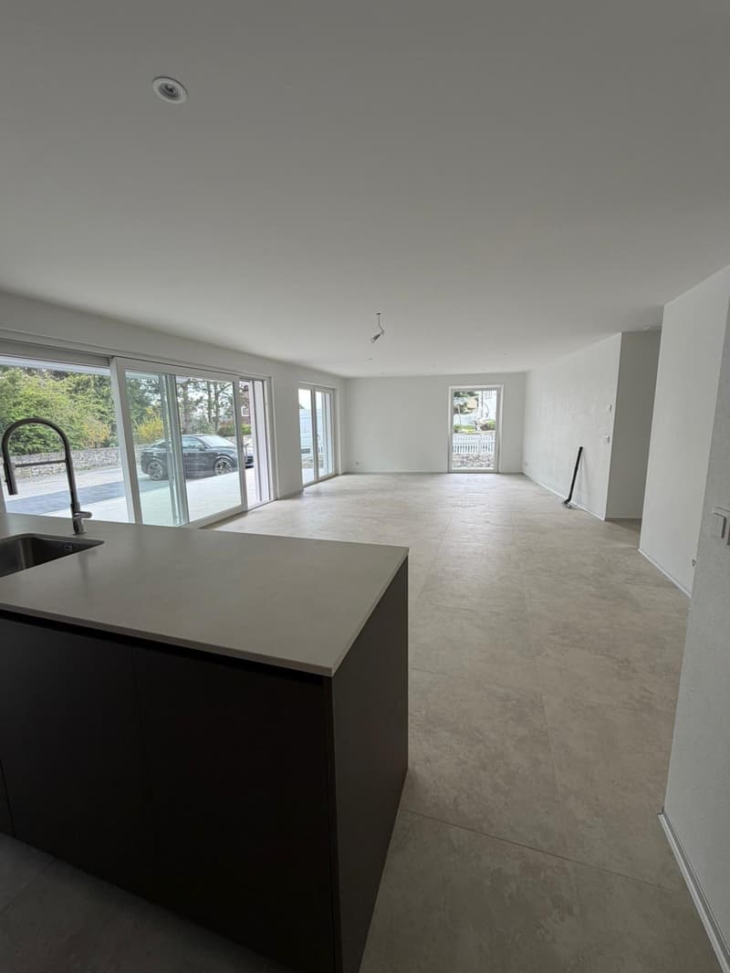 empty room, large windows, tiled floor, kitchen island with sink and faucet