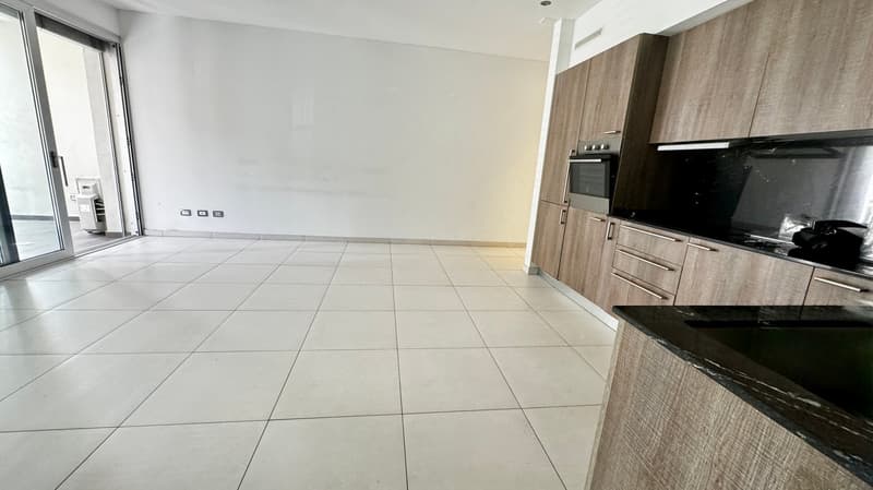 white floor tiles, white walls, sliding glass door to balcony, modern kitchen, oven, sink