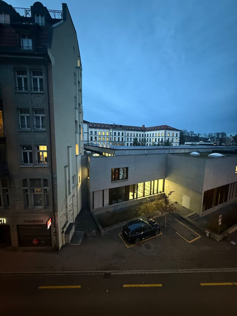 modern building with windows, parking space with car, illuminated windows