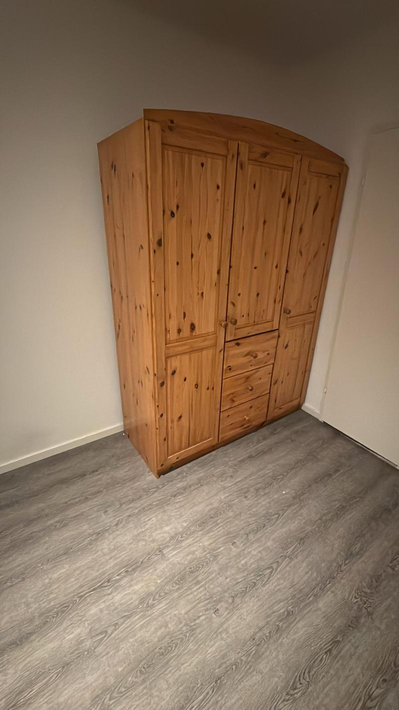 wooden wardrobe, tiled floor, white walls