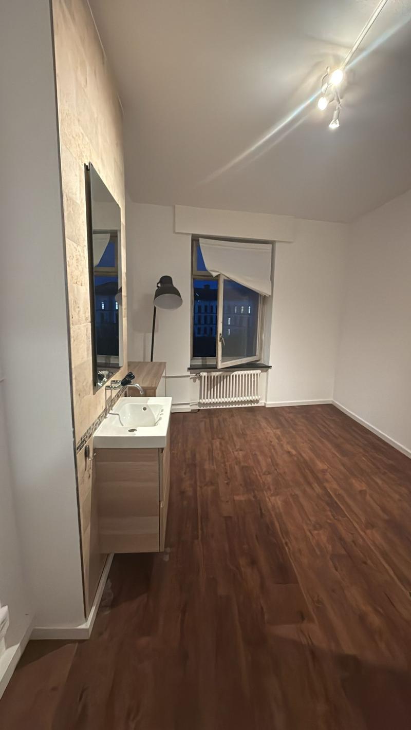 bathroom with white sink, mirror, tiled wall, radiator, floor lamp, open window, wooden floor
