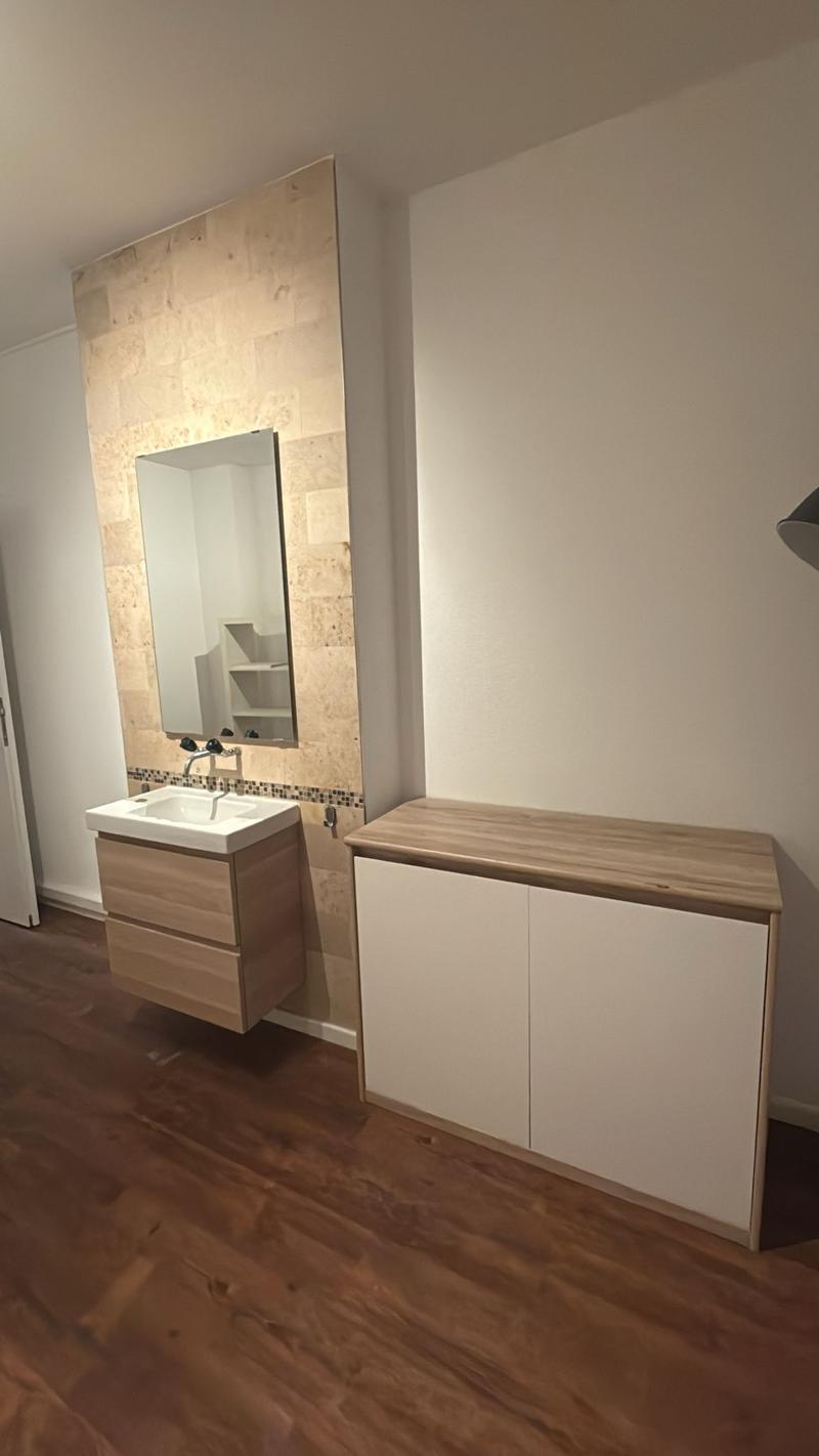 Bathroom with modern fixtures and wooden floor.