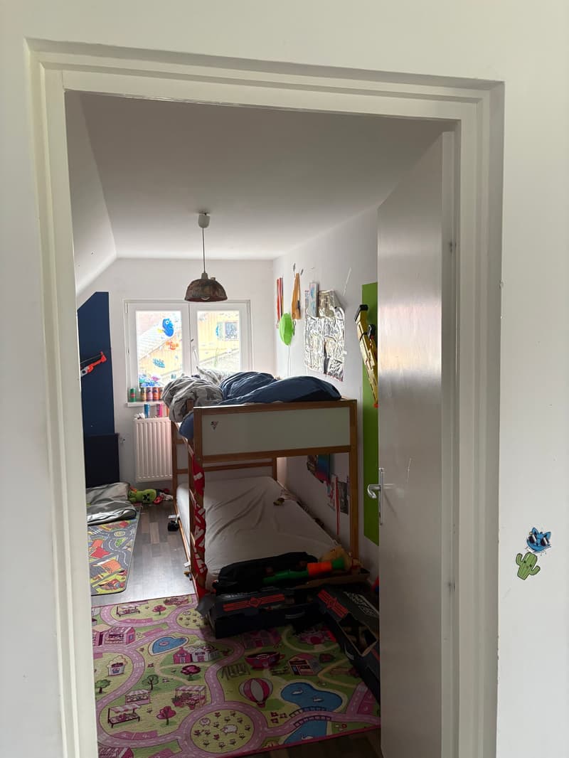 room with bunk beds, toys, lamps, rug, radiator, window