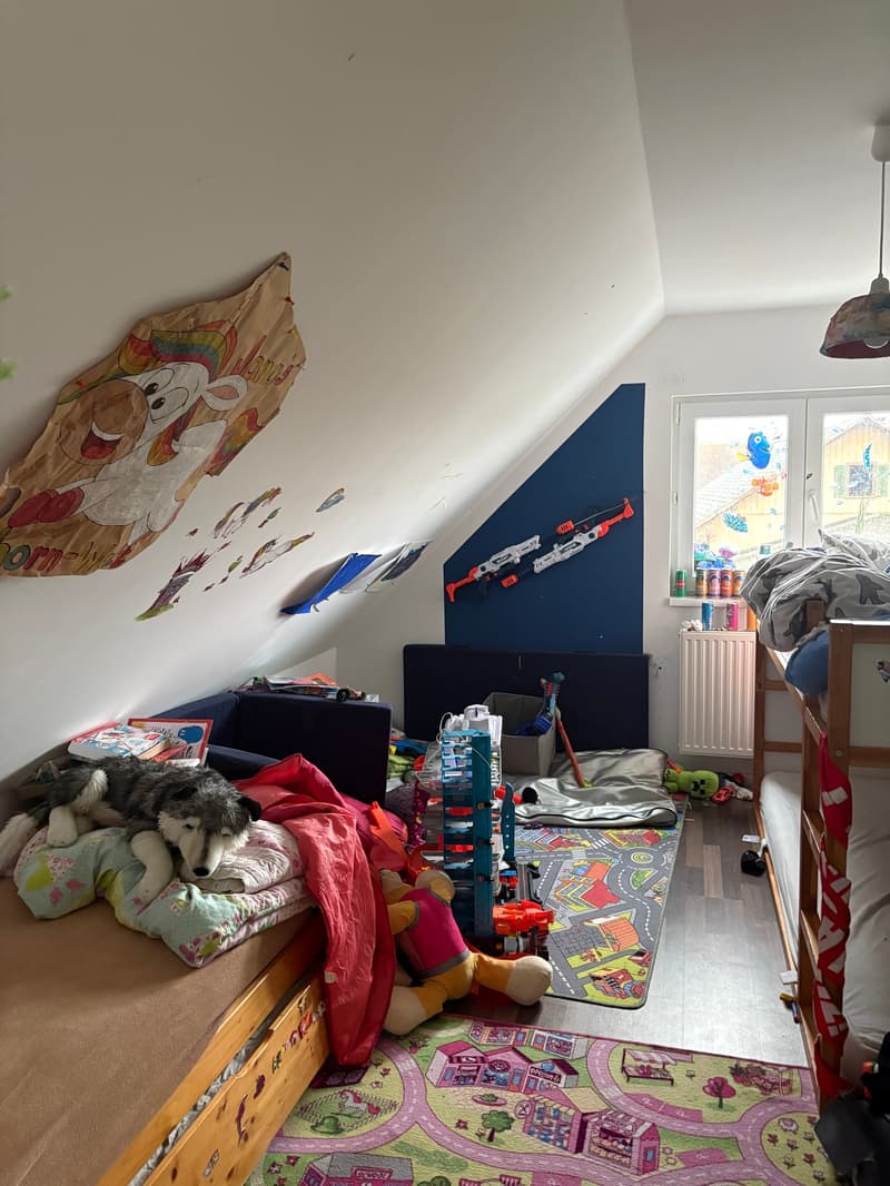 Children's room, carpet, bunk beds, toys, couch, pillow with dog, wall decorations