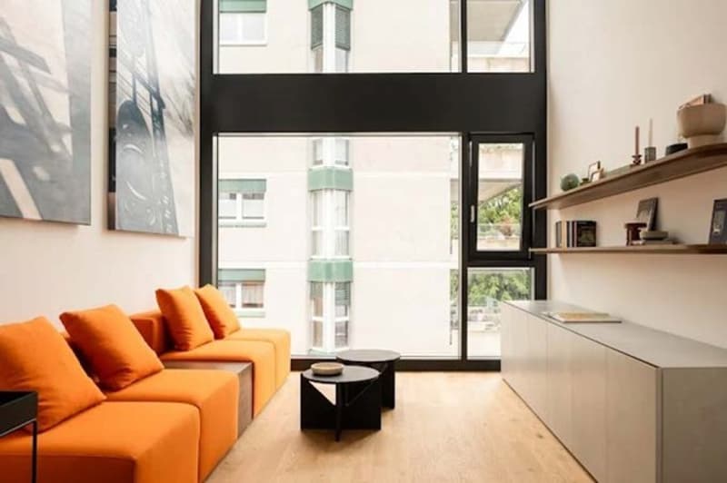 living room with orange sofa, large windows, wooden floors, modern decor