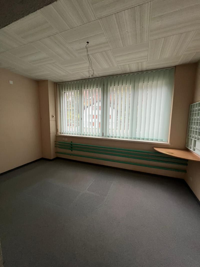 Empty room, blank walls, window with vertical blinds, wooden shelf next to the window