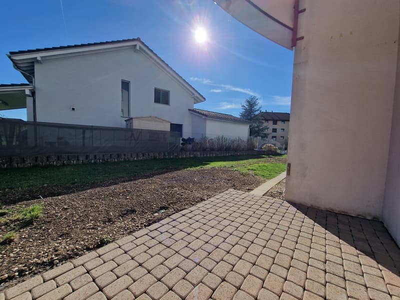 brick paved walkway, grassy area, fence, house in the background