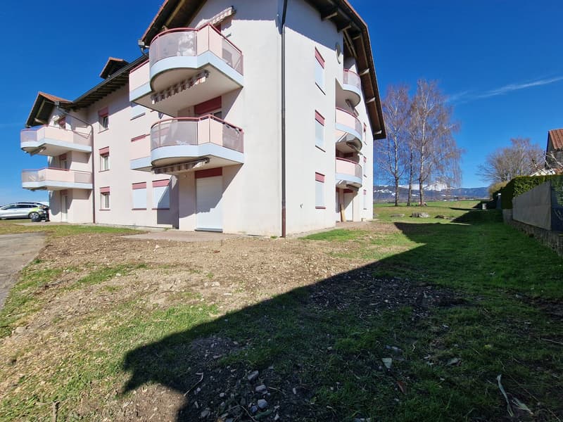 3 story apartment building, white exterior, pink accents, multiple balconies, car parked in front