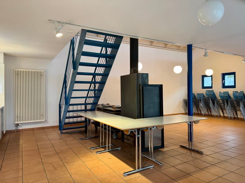 two tables, metal stand, blue metal staircase, lamps, white radiator, chairs