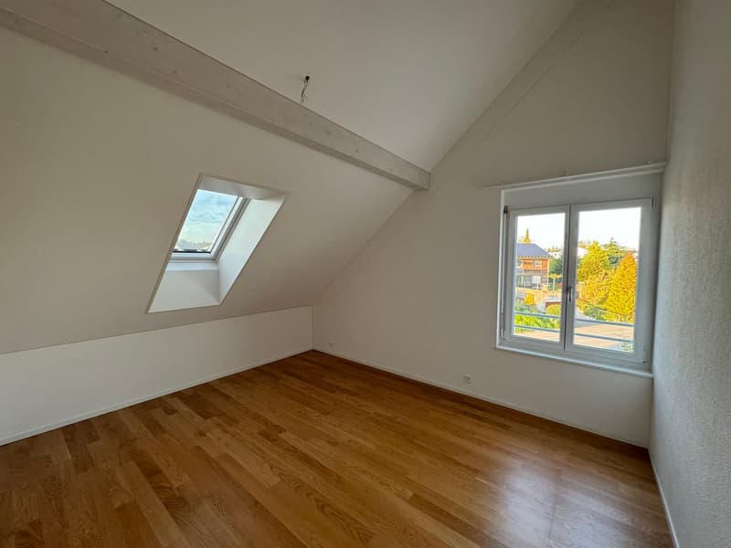 empty room, wooden floor, white walls, two windows, one with a view