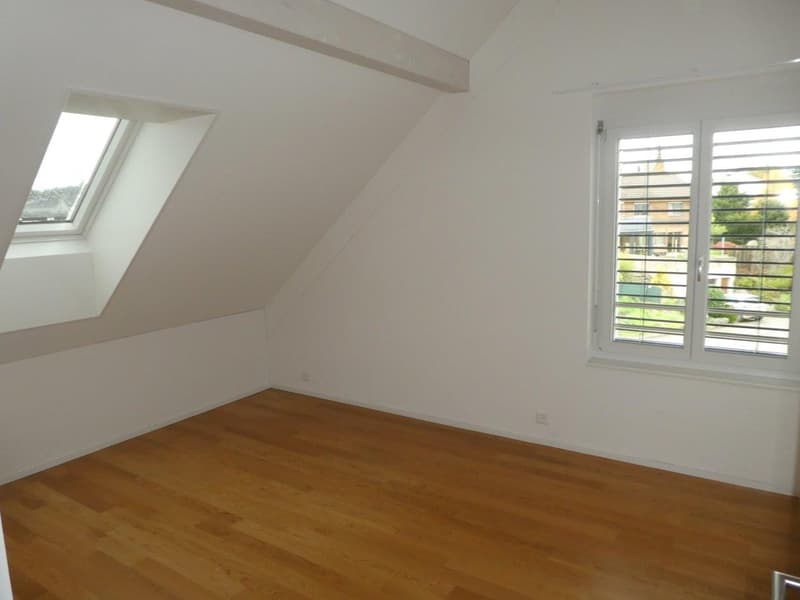 empty room, wooden floor, white walls, two windows, one with shutters, one skylight
