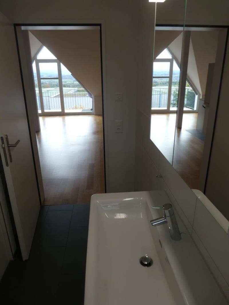 Bathroom with white sink, mirror, and balcony with view