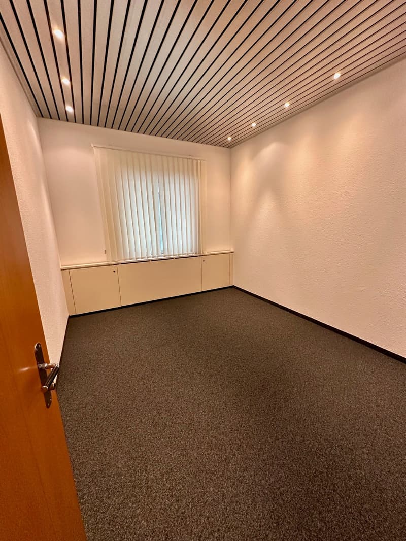 empty room, white walls, carpeted floor, window with blinds, wooden door