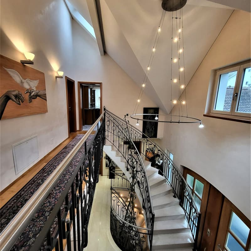 marble staircase, black railings, white marble steps, decorative lights, wooden doors, wall paintings