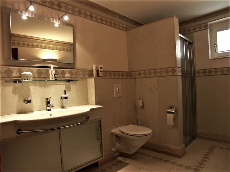modern bathroom with white sink, mirror, toilet, shower, and tiled floor