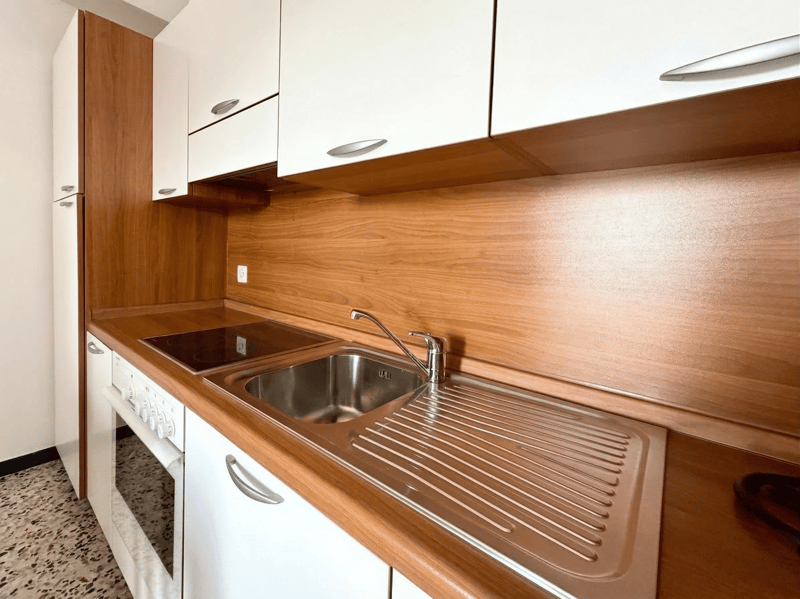 modern kitchen with wooden cabinets, stainless steel sink, gas stove, oven, dishwasher, washing machine