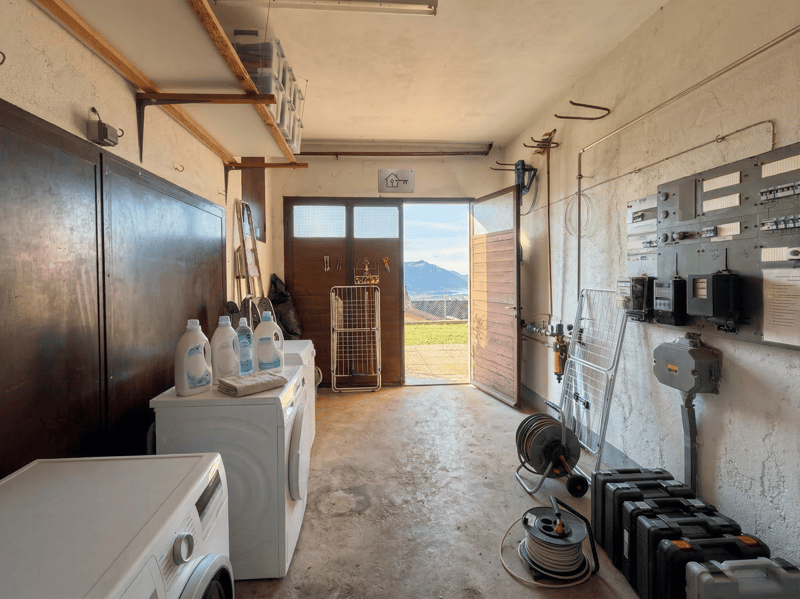 Laundry room with washing machines, storage shelves, and a drying rack.