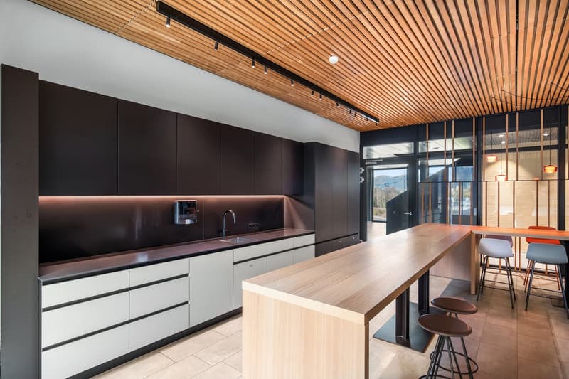 modern kitchen with wooden ceiling, kitchen island, black cabinets, modern faucet, white drawers, tiled floor