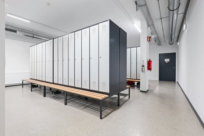 white lockers, grey concrete floor, benches, fire extinguisher