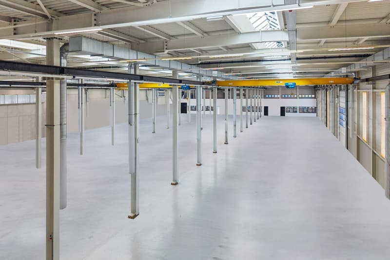 empty warehouse, white floor, white walls, white ceiling, several support columns, windows, ventilation ducts