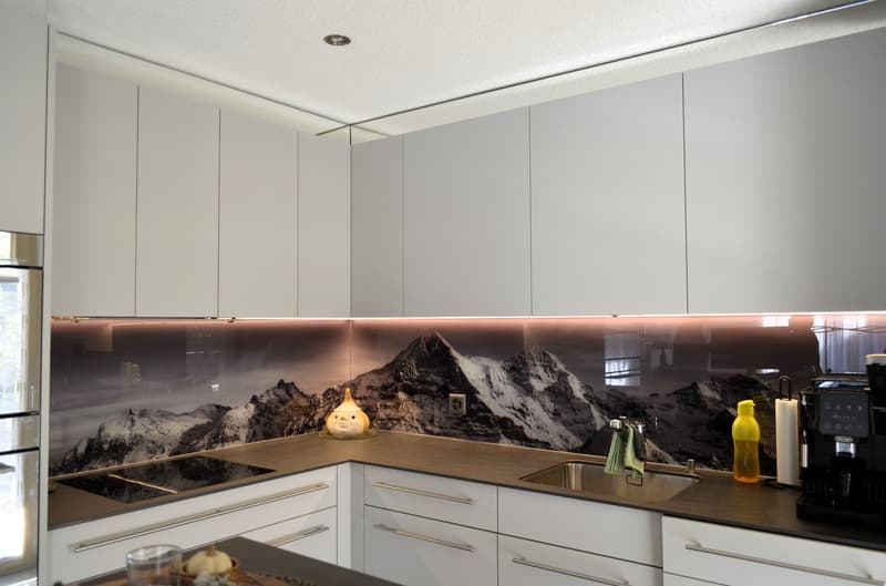 white cabinets, granite countertops, integrated stove, under cabinet lighting, stainless steel appliances, large mountain photo