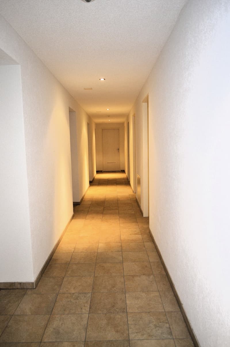 Empty hallway with white walls and tiled floor