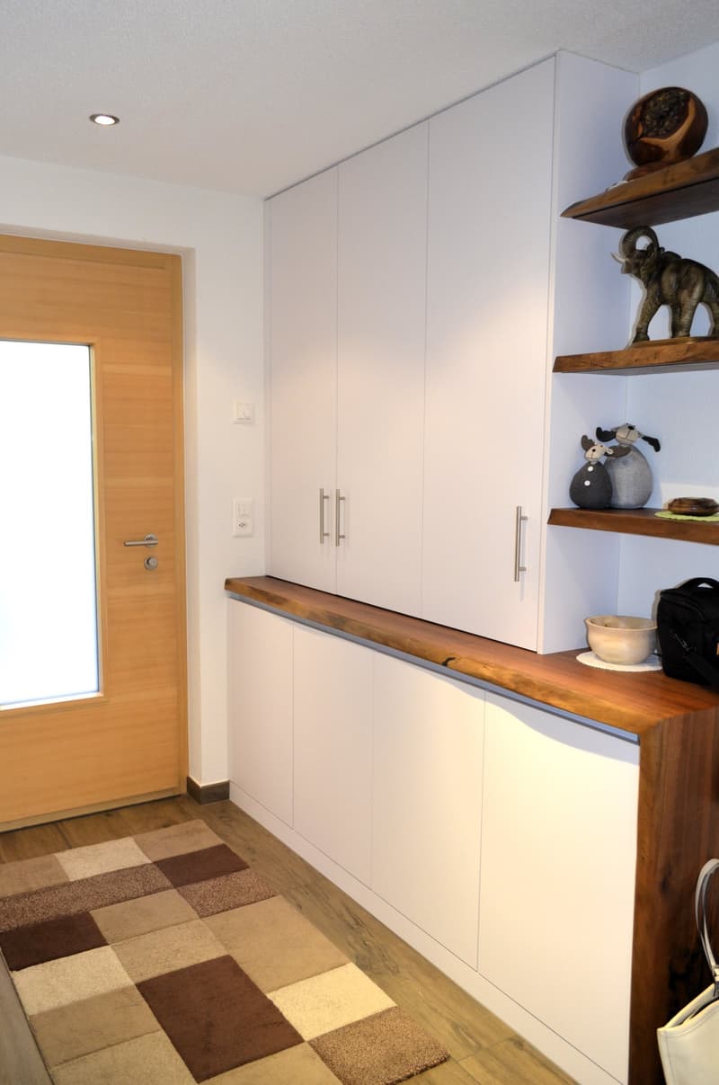 white cabinets, wooden countertop, rug, wooden door, wooden floor, light