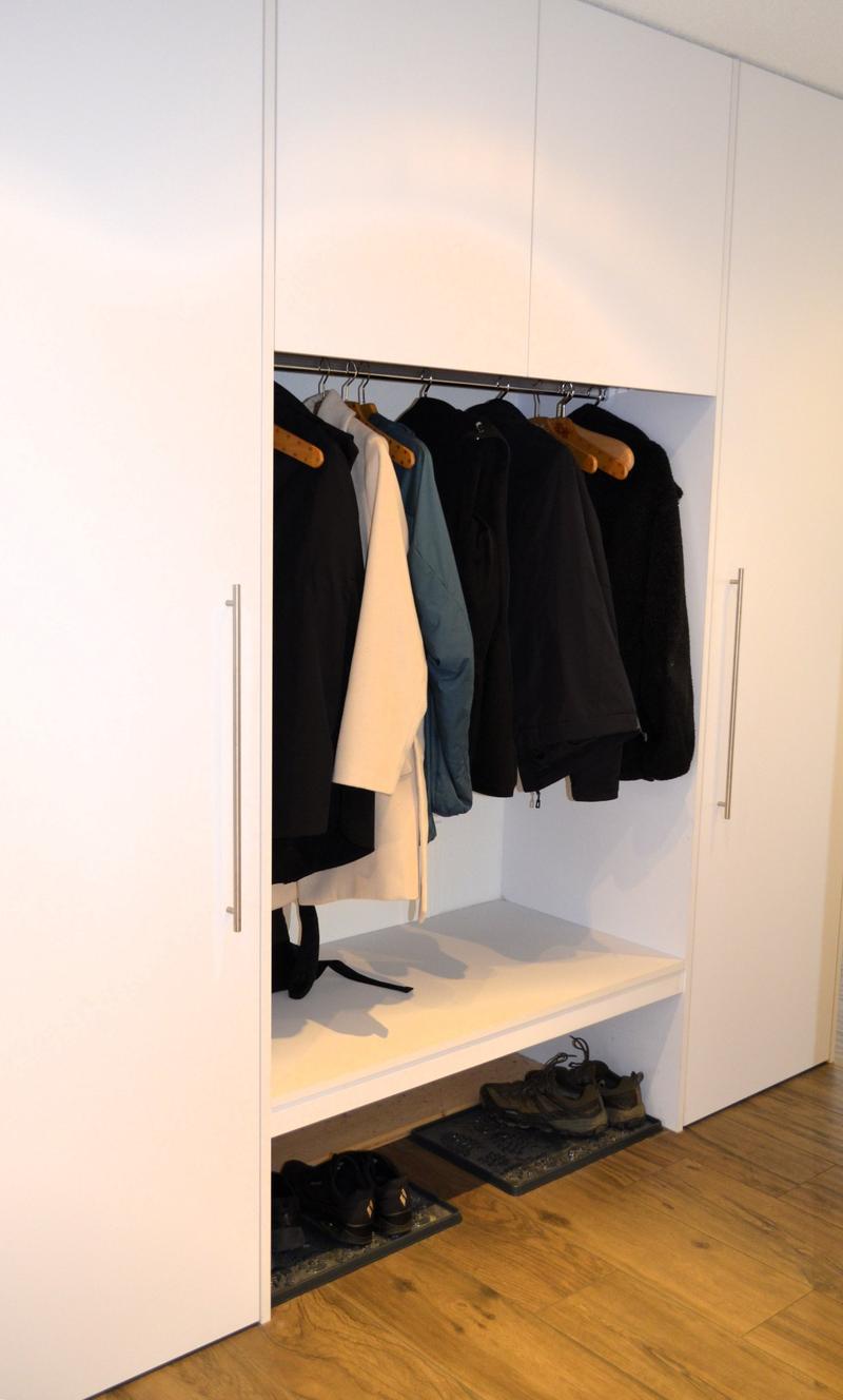 large walk-in closet with built-in shelves and benches, wooden flooring